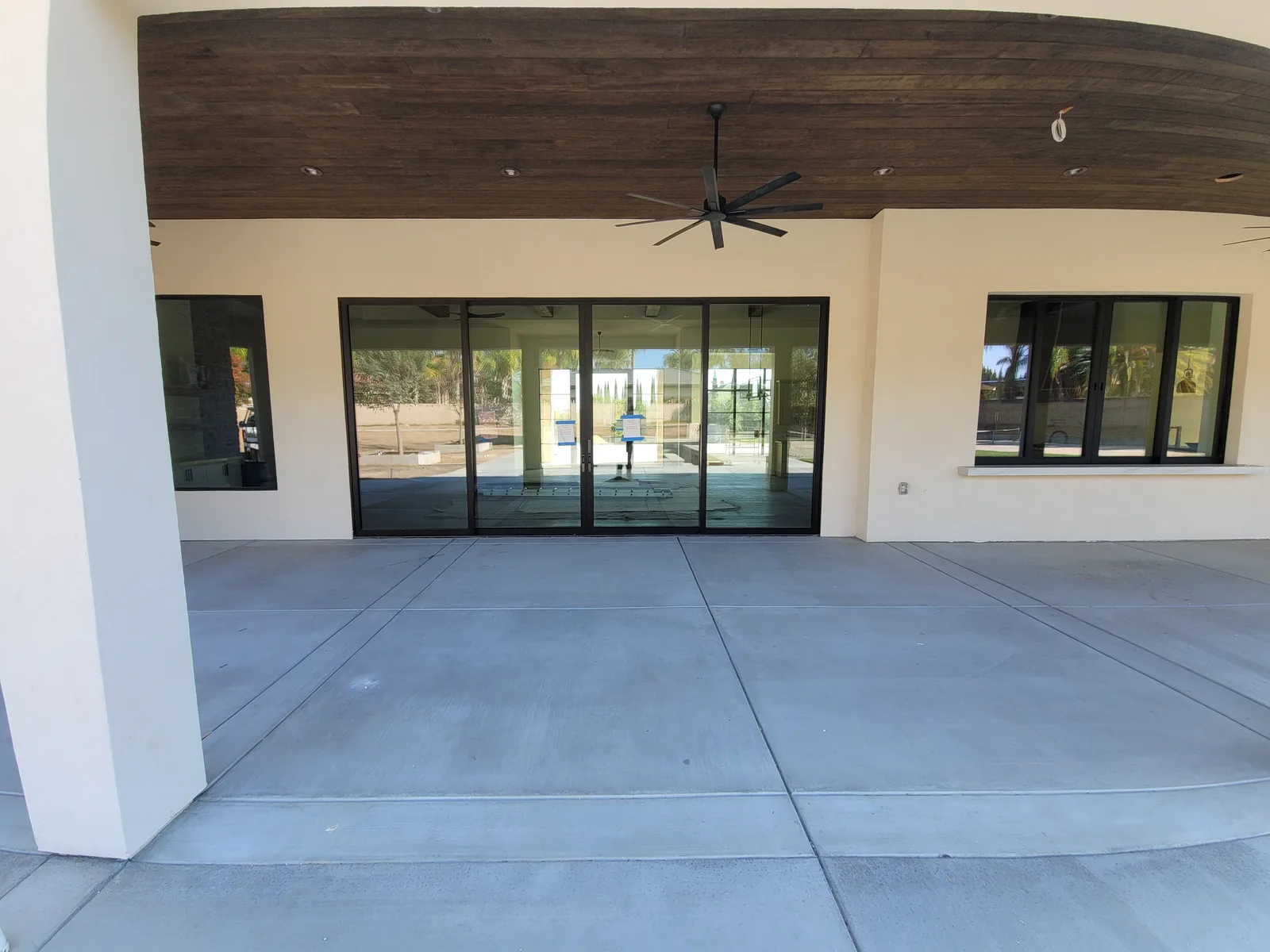 Covered patio lined with windows and a sliding door